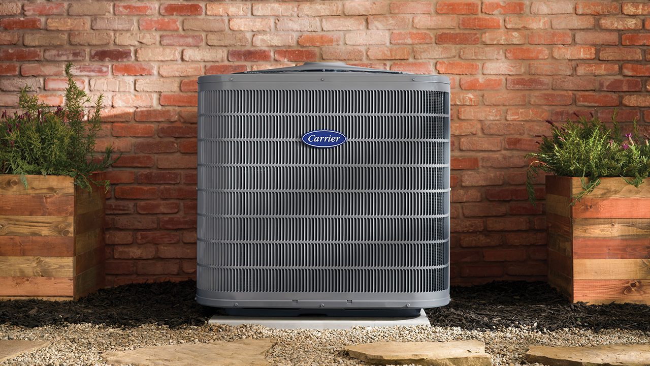 A Carrier condenser maintained beside a brick home