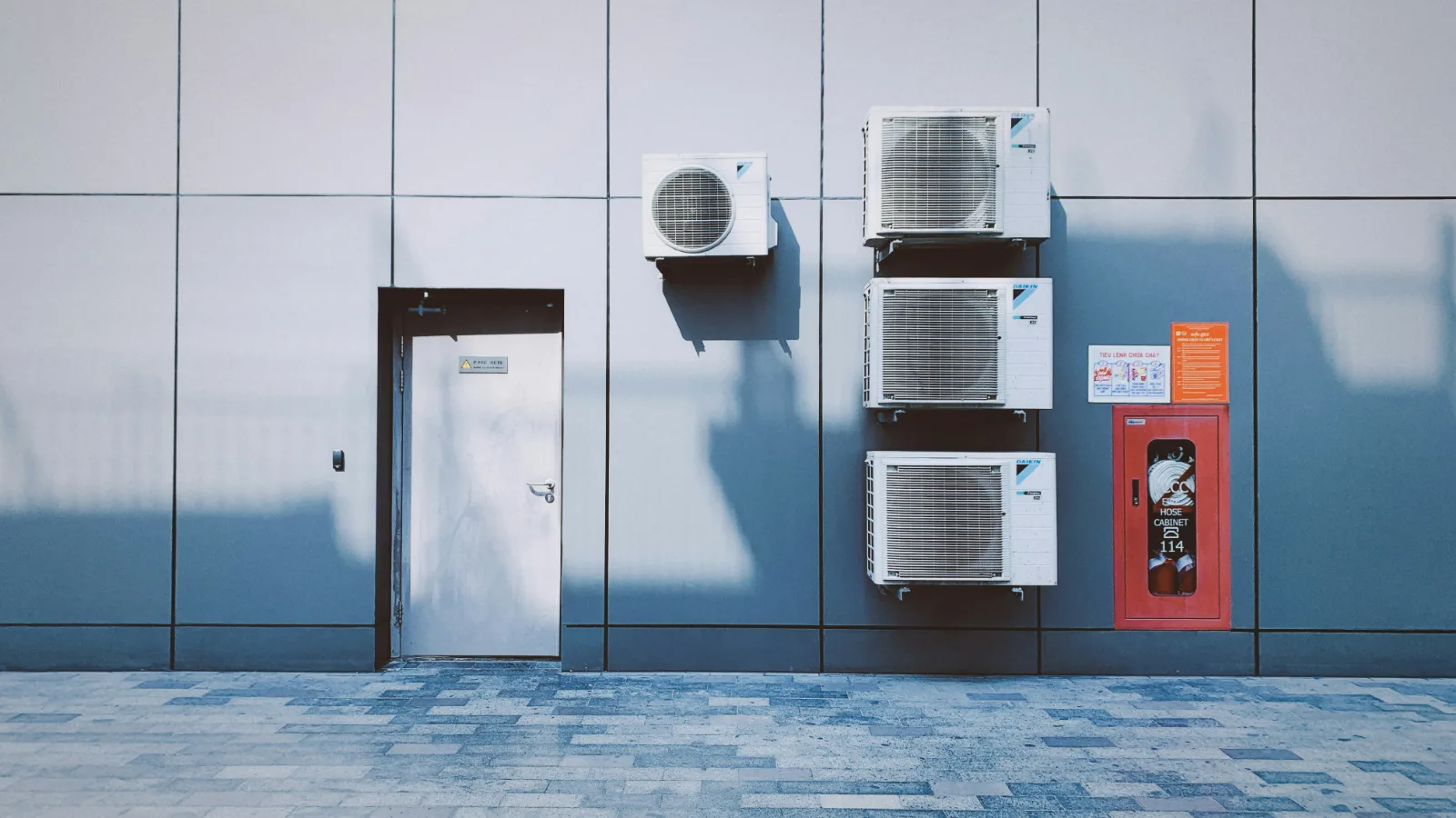 A clean grid of air conditioning condenser units on a wall